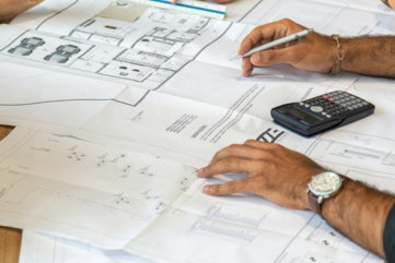 people reviewing architectural blueprints on desk
